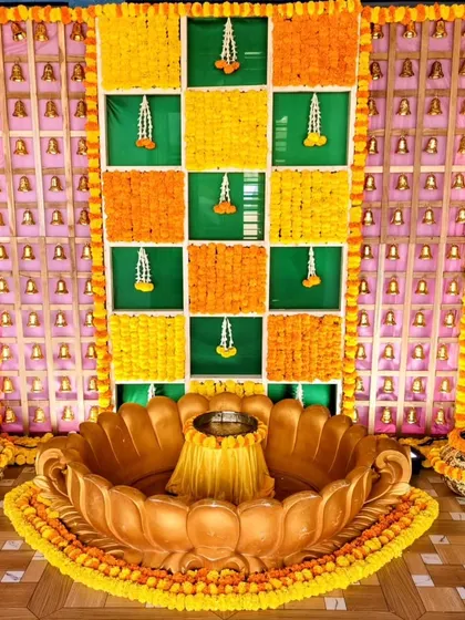 A vibrant Haldi ceremony backdrop made of marigold flowers in a checkerboard pattern.