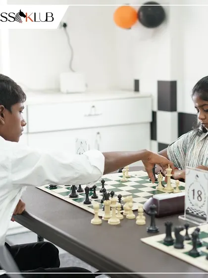 Two young players are locked in a strategic battle during a tournament. We provide a platform for kids to develop their competitive chess skills from an early age.