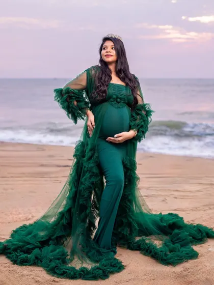 The full splendor of the ruffled green gown is on display in this stunning portrait, making the mom-to-be look like a mermaid emerging from the sea.