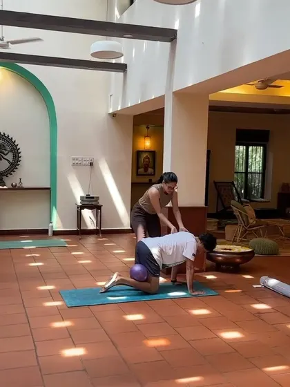 In this shot, I'm assisting a client with a quadruped exercise using a pilates ball for added stability and core engagement. This helps activate deep abdominal muscles and improve balance.