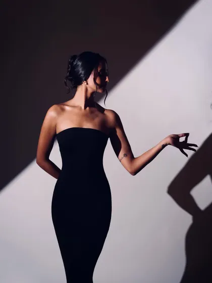 A minimalist portrait focusing on the silhouette and the expressive potential of a single hand gesture.