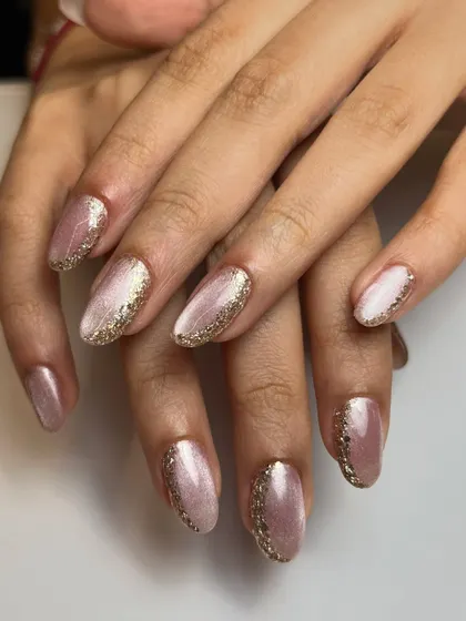 Both hands, showing off the simple and elegant cat-eye and gold glitter design. It's a perfect look for any occasion.