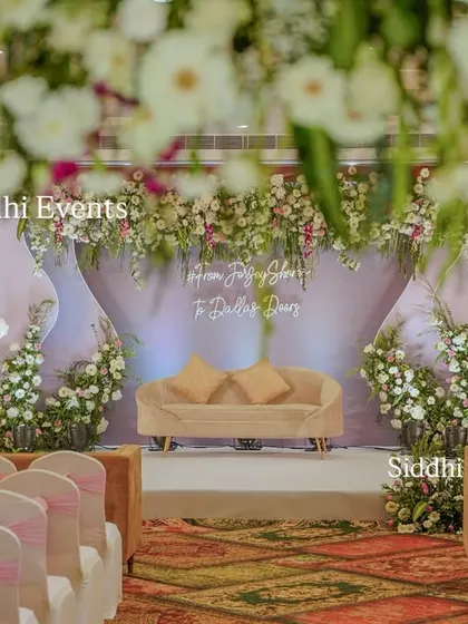 An intimate view of the engagement ceremony setup, showing the elegant guest seating with pink sashes leading to the beautifully decorated floral stage.
