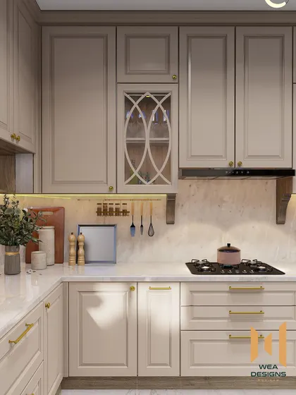 A close-up of the hob area, showing the elegant cabinet details and brass handles.