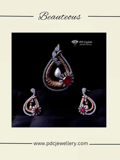 A beauteous diamond pendant set in 18kt hallmarked gold. This ornate design combines a central pearl, a red gemstone, and sparkling diamonds in a teardrop shape.