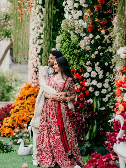 Another beautiful shot of the couple surrounded by the vibrant floral decor. The mix of textures and colors from the flowers creates a rich and lively background for their special day.