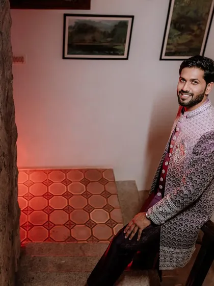 A happy portrait of the groom on a staircase, looking ready for his reception.
