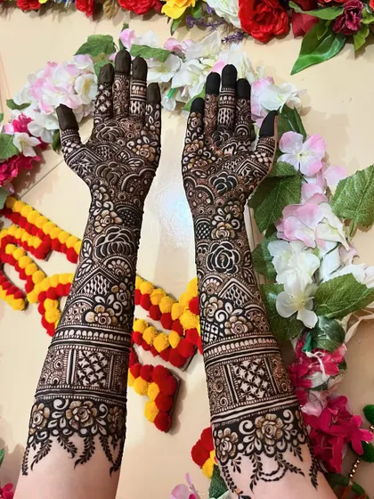 The back of the hands for a bridal set, featuring beautiful floral bands and patterns that extend from the wrist to the fingertips.