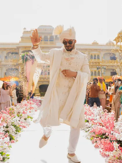 The groom makes his grand, energetic entrance for the wedding, dancing down the aisle with style and confidence.
