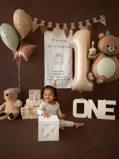 A joyful smile from the birthday boy in our teddy bear themed setup. The coordinating balloons, banner, and props create a cohesive and adorable look.