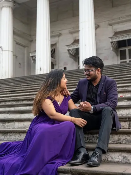 A quiet, intimate moment on grand steps. The cascading purple trail of her gown adds a touch of royalty and romance to this beautiful couple's pre-wedding portrait.
