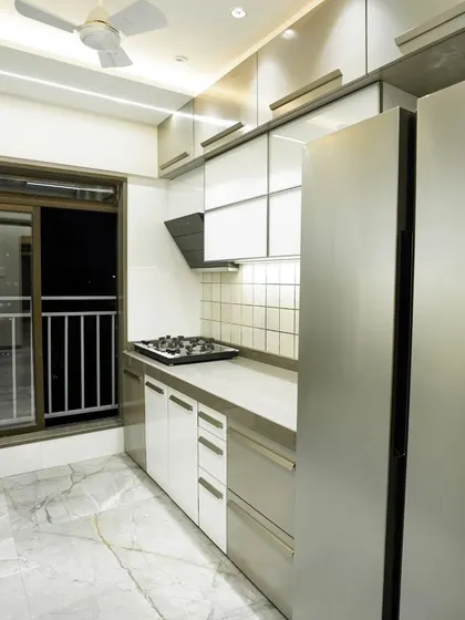 This parallel kitchen design features a clean, modern aesthetic with white and grey cabinets. The layout provides ample counter space and integrates the refrigerator seamlessly.