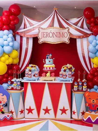 I designed this vibrant, circus themed birthday party for a child's celebration. The setup includes a custom backdrop with red and white stripes, a personalized "Jeronimo" sign, and colorful balloon garlands in red, blue, and yellow to create a fun and festive dessert table.