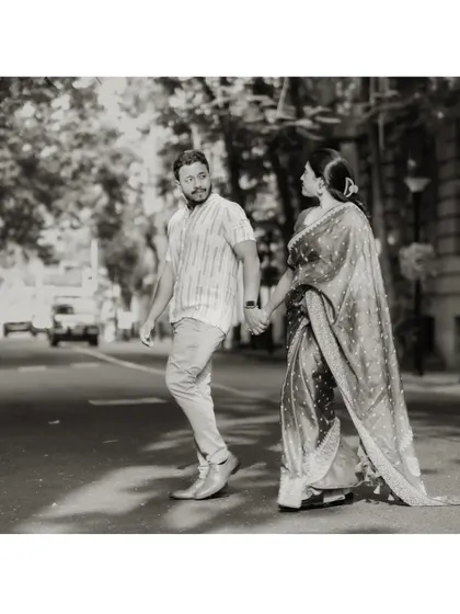 A timeless black and white photo of the couple crossing a city street, hand in hand. It feels like a scene from a classic movie.