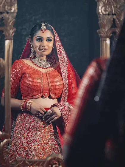 A regal shot of our model in a red sequined bridal lehenga, available for rent. This outfit is all about glamour and is perfect for a grand reception.