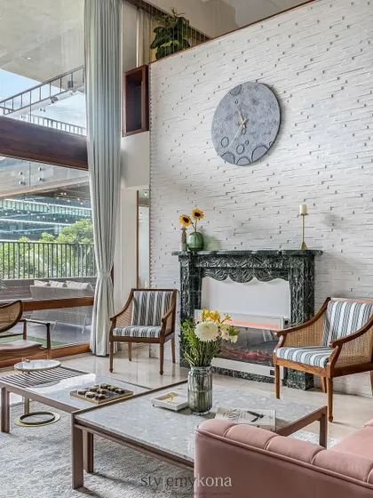 Another view of the living room, showcasing the custom moon wall clock and the elegant fireplace, which together create a unique and cozy focal point.