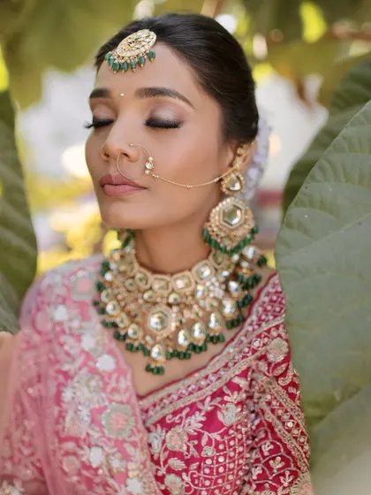 A close-up of a soft glam bridal look with a pink lehenga. The focus is on shimmery eyelids and glowing skin, creating a dreamy and ethereal effect.