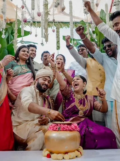 The triumphant moment when love wins. Surrounded by cheering family, this candid shot is bursting with energy, celebration, and the collective joy of the wedding day.