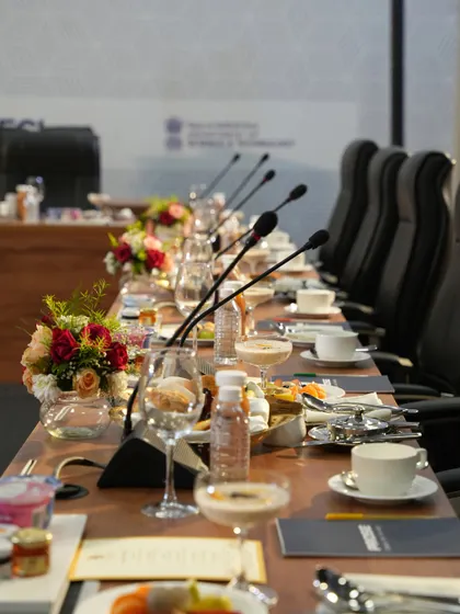 A long table set for a ministerial or CEO-level meeting. We provide all-day catering for such events, including refreshments, working lunches, and formal dinners.