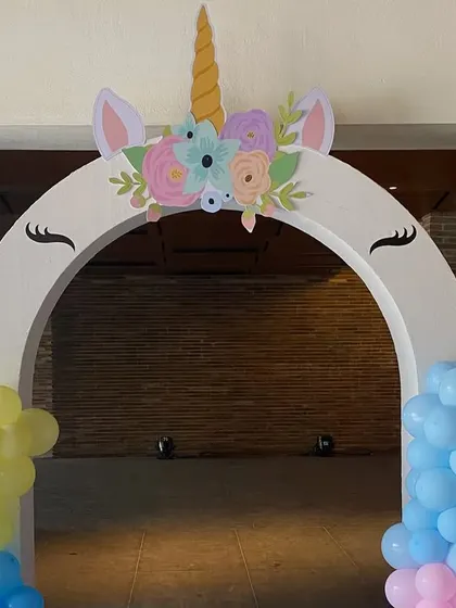 A simple yet charming unicorn-themed entrance arch. The white arch is adorned with a unicorn horn and ears, and flanked by pastel balloon clusters, providing a perfect welcome to a magical party.