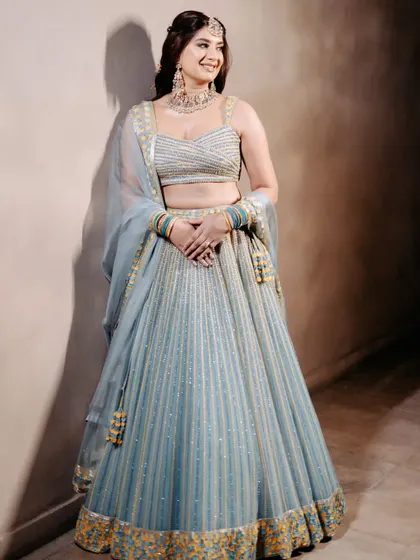 This bride chose an unconventional powder blue lehenga for her Sagan ceremony. The intricate work and fresh color create a look that is both elegant and modern.