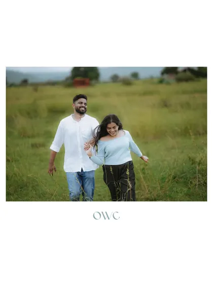 A wide shot of a couple running joyfully through a field, capturing the freedom and happiness of their pre-wedding moments.