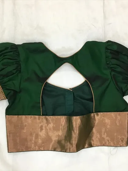 A classic green blouse with puffed "Bahubali" sleeves made from a traditional saree border.