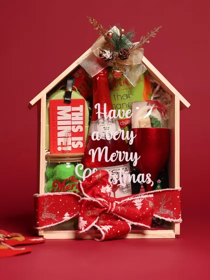 My house-shaped Christmas hamper is a festive favorite. It's filled with holiday treats, a Christmas-themed mug, and other goodies, all tied with a beautiful red ribbon.