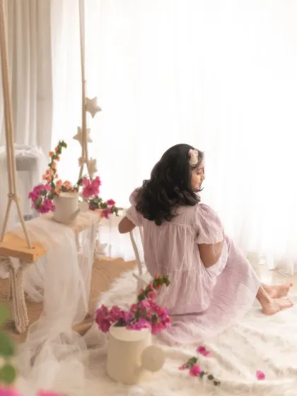 A beautiful, atmospheric shot of the girl in the spring-themed setup. The backlighting and her pose create a sense of peace and nostalgia.
