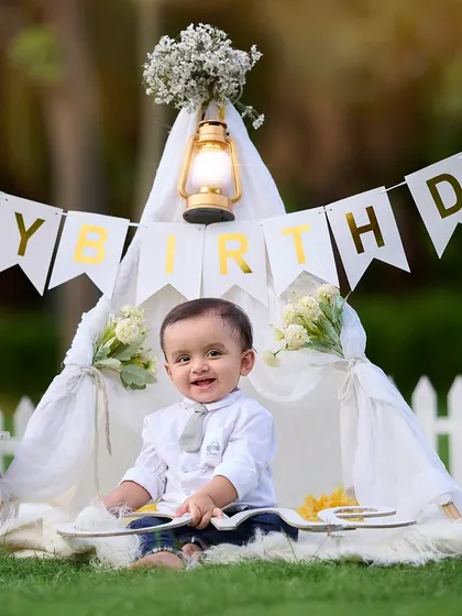 The "Boss Baby" theme is a client favorite for first birthdays. Here, I've created a charming setup with a teepee tent, a "Happy Birthday" banner, and a lantern for a warm, celebratory feel.