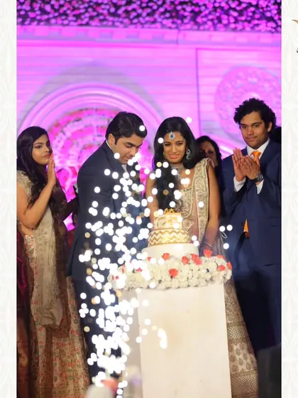 A joyous moment of cake cutting, enhanced by the sparkle of cold pyrotechnics. I ensure even small moments are framed beautifully with the right lighting and effects.