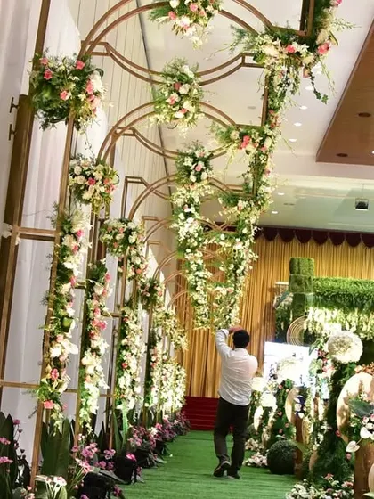 An elegant floral archway leading into the main wedding hall. This creates a beautiful and welcoming entrance for guests, setting the tone for the grand celebration inside.