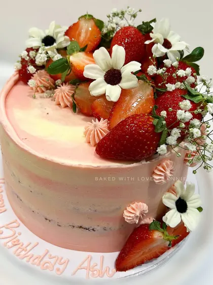 A custom Dark Chocolate Strawberry Cake I created for a special birthday. It features layers of moist chocolate sponge and creamy ganache, finished with soft pink vanilla buttercream and fresh strawberries.