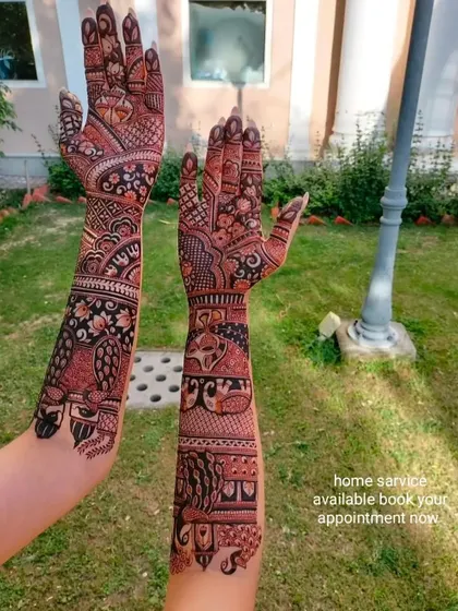 This photo, taken outdoors, shows how the dark henna stain looks beautiful in natural light. The design features peacocks and other traditional story elements.