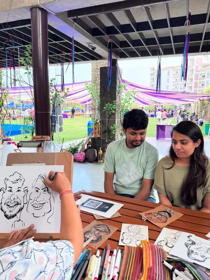 A behind-the-scenes shot of me drawing a couple at the ISB alumni meetup.