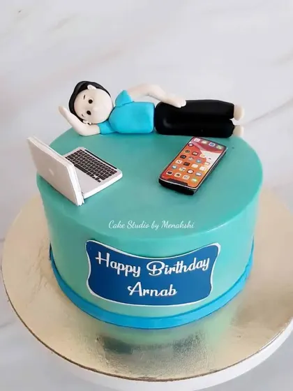For Arnab, who loves to work and sleep. This cake shows him relaxing with his laptop and phone, a fun and relatable design.