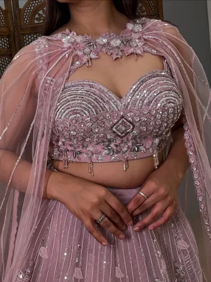 A detailed close-up of the heavily embellished blouse and the unique cape neckline. The craftsmanship on this pre-loved piece is exceptional.
