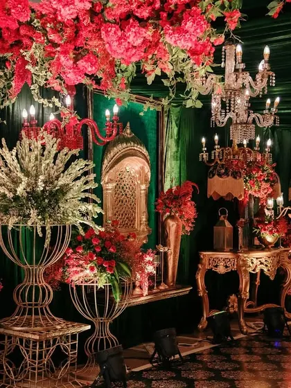 A close-up view of the regal decor, highlighting the interplay of red florals, golden accents, and crystal chandeliers. Every corner is meticulously styled to whisper luxury.