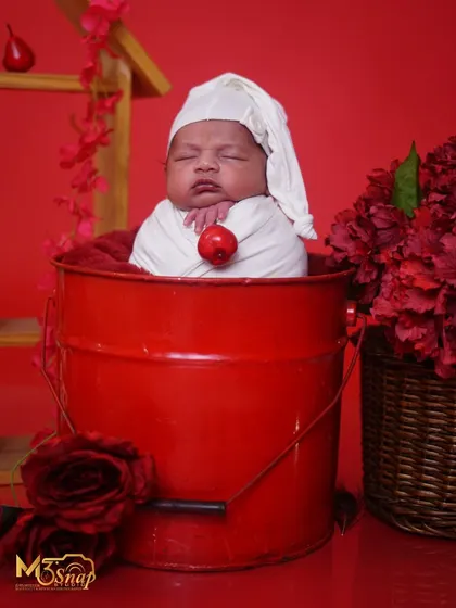 Another angle of this adorable setup, showing the baby's peaceful slumber amidst the festive red decor.