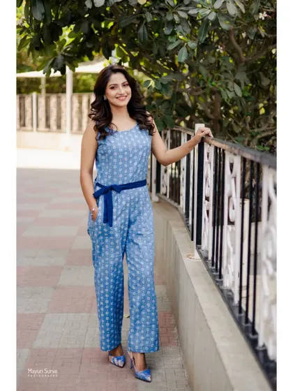 A full-length fashion portrait. This shot showcases the entire outfit, a stylish blue printed jumpsuit, giving a complete look for a brand collaboration or portfolio.