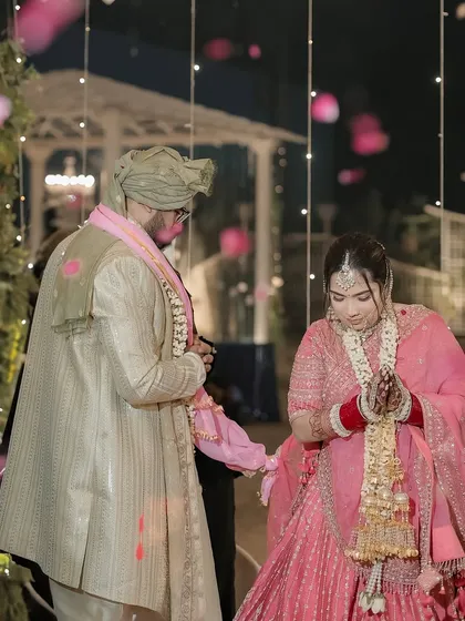A quiet moment during the wedding ceremony, with the couple sharing a look as they are showered with petals.