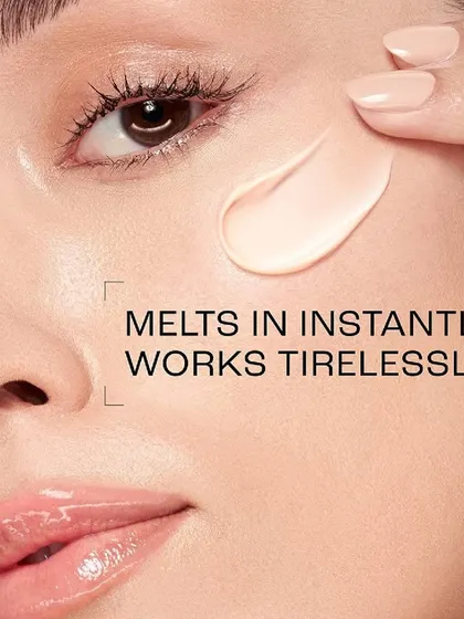 A macro beauty shot for a Lakmé skincare advertisement, demonstrating the product's texture. The image shows a creamy formula being applied to the model's cheek, with text overlay explaining how it "melts in instantly," focusing on the sensory experience of the product.
