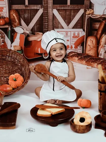 A happy little chef playing with a big wooden spoon. Our chef theme is full of fun props that encourage play and result in wonderfully natural and expressive photos.
