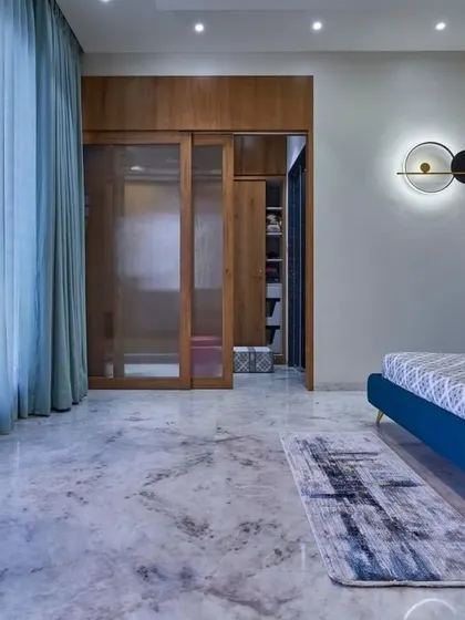 Another view of this spacious bedroom, showing the walk-in closet concealed behind sliding glass and wood doors. The design maintains a clean, uncluttered look while providing ample storage.