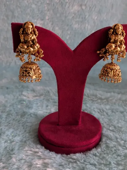 These are the matching Lakshmi jhumkas, featuring a detailed deity motif and classic bell shape. They are a perfect complement to the Kaasu necklace set.