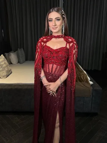 The crimson red gown, a true showstopper that exudes confidence and luxury with its flawless tailoring and intricate design.