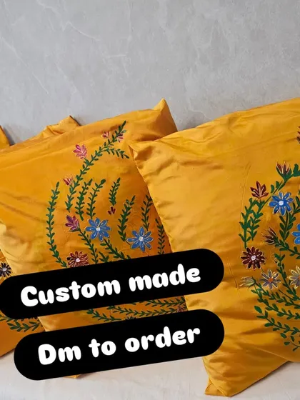 A close-up of the custom-made yellow silk cushion covers with hand-painted floral designs. These are perfect for adding a pop of color and a personal touch to your sofa or bed.