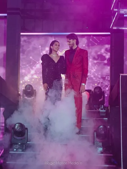 The couple makes a grand entrance onto the Sangeet stage through a cloud of smoke.