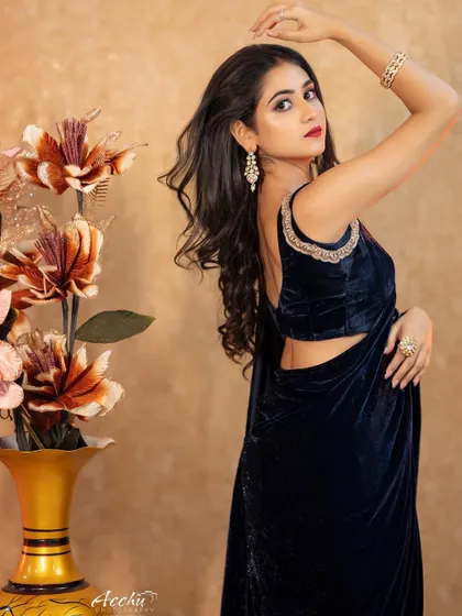A modern take on a velvet saree. The deep blue fabric and backless blouse design are highlighted with studio lighting for a look that is both traditional and bold.
