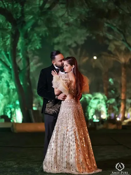 A reception portrait set against the enchanting green-lit woods. The groom's tender embrace and the bride's elegant gown create a fairytale-like image, capturing the magic of their celebration.